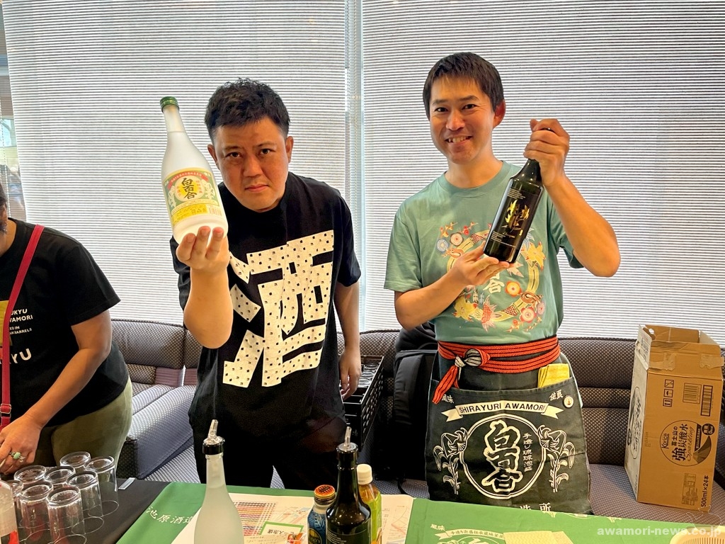 池原酒造ブースには、キメポーズで「白百合」を掲げる池原社長(左)と有志のシラユリスト